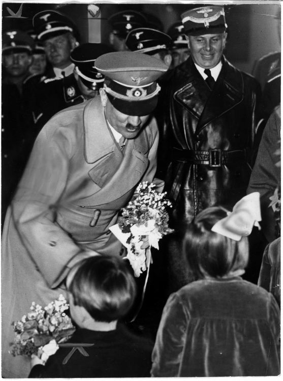 Adolf Hitler is greeted by children as he leaves Berlin's Anhalter station at his return from Austria